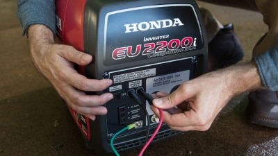 Two hands connecting EU2200 Generator.