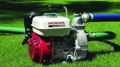 Plan étendu d’une pompe à eau sur une pelouse, les tuyaux branchés. 