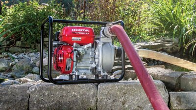 Plan étendu de la pompe de transfert reposant sur des pierres, le tuyau branché. 