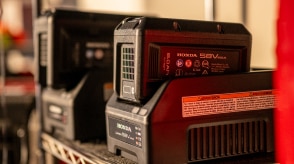 Deux batteries de tondeuses à batterie sur leur chargeur dans le garage. 