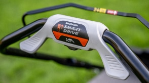 Gros plan de la poignée de la tondeuse montrant le bouton du système Smart Drive. 